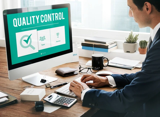 Seorang pria bekerja di depan layar komputer dengan tampilan sistem Quality Control.